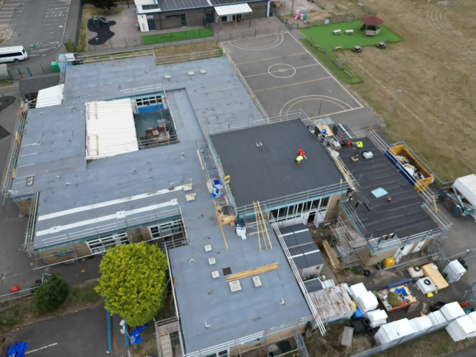 Aerial overview of school roof refurbishment works in progress with scaffolding and temporary protection