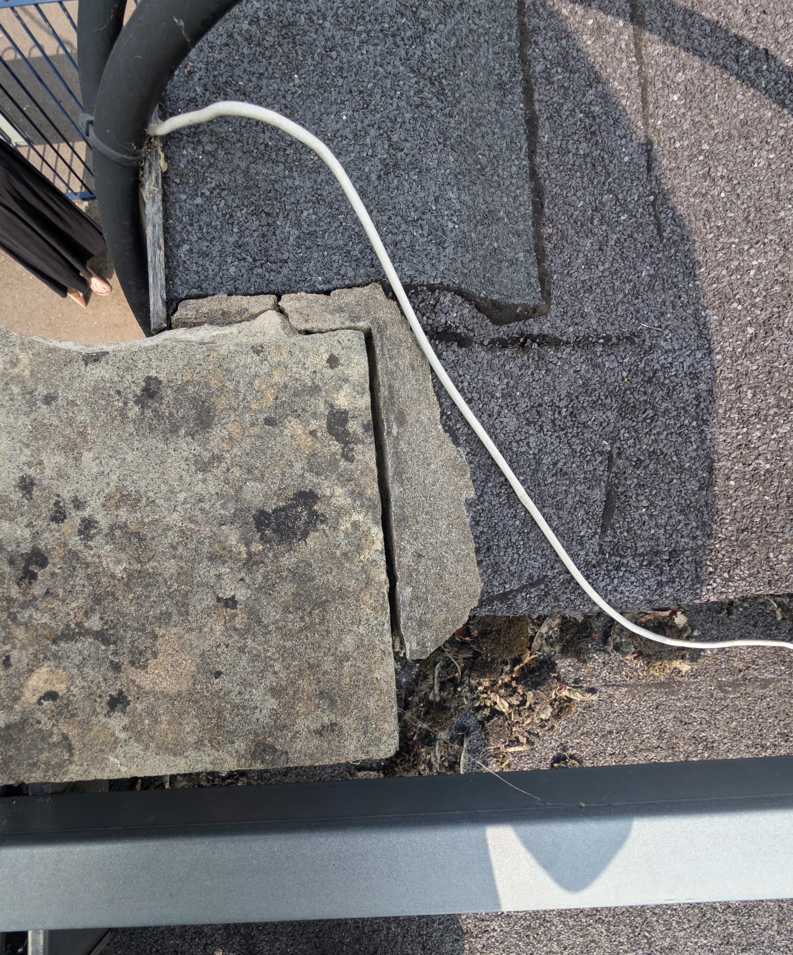 Summer roof inspection showing displaced paving slabs and a failed detail at a flat roof edge
