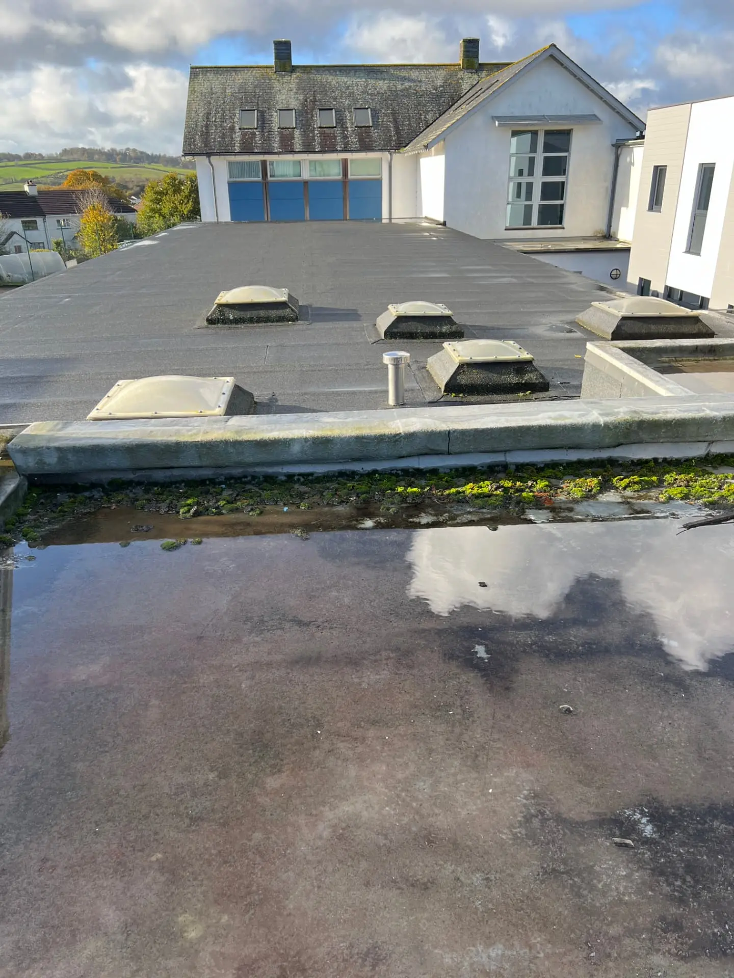 Ponding water on a commercial flat roof during a condition survey