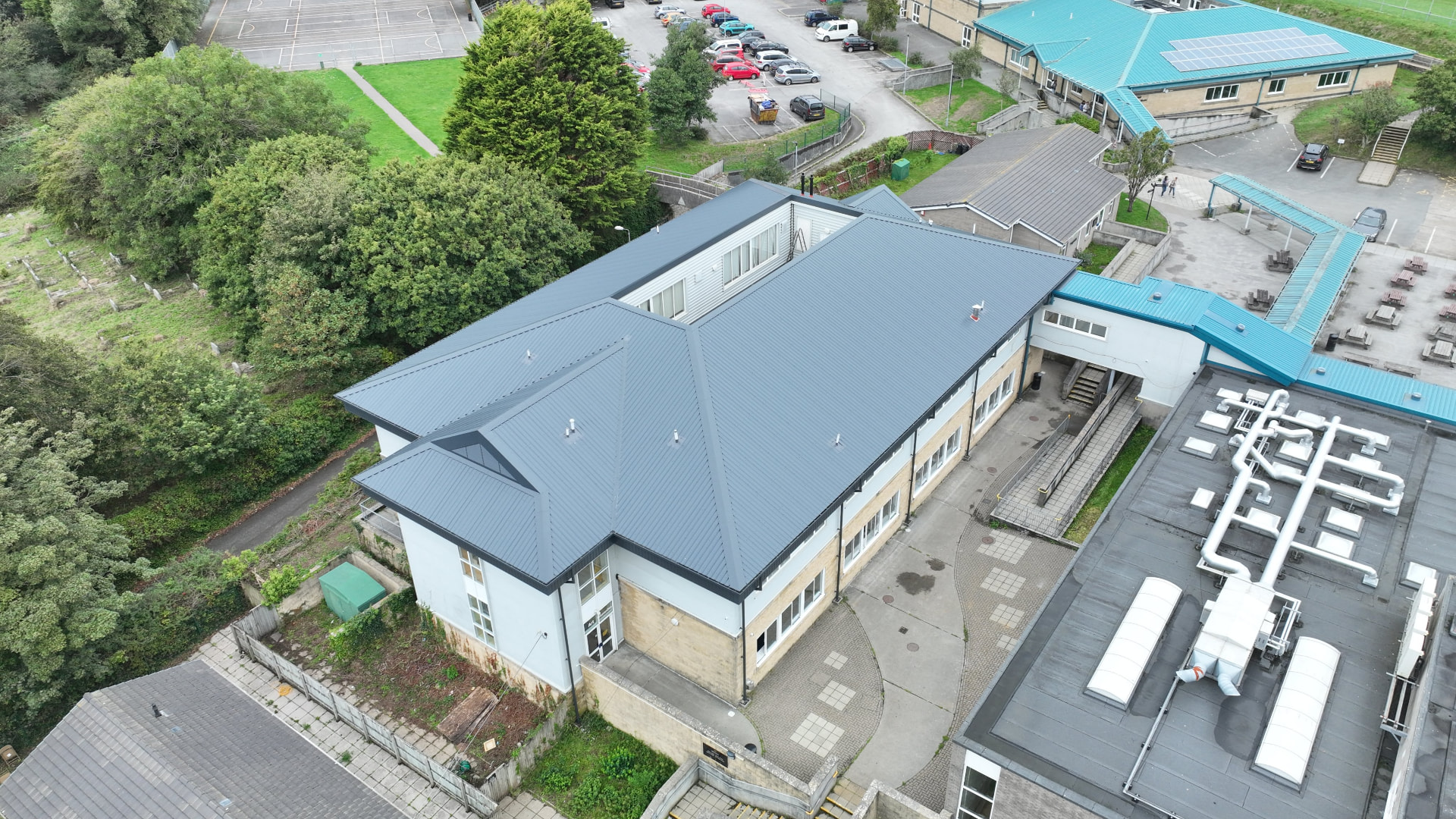 Aerial view of the completed grey metal overclad roofs at Pool Academy, Redruth