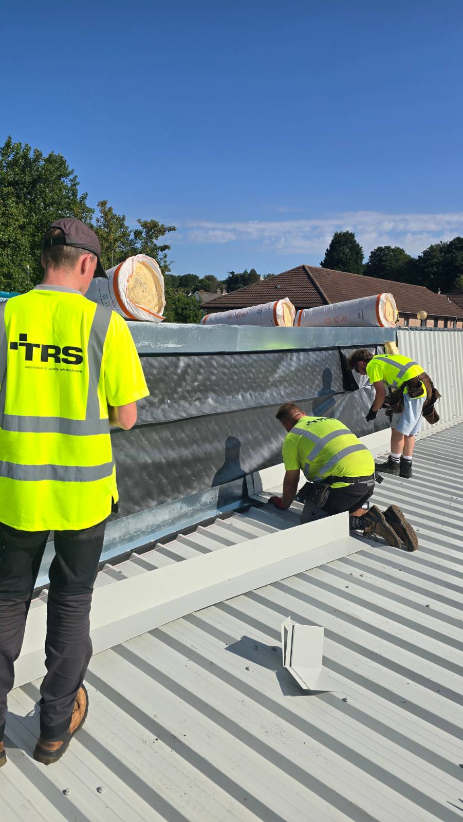 TRS team installing insulation and metal cladding at a roof upstand at Faith Church