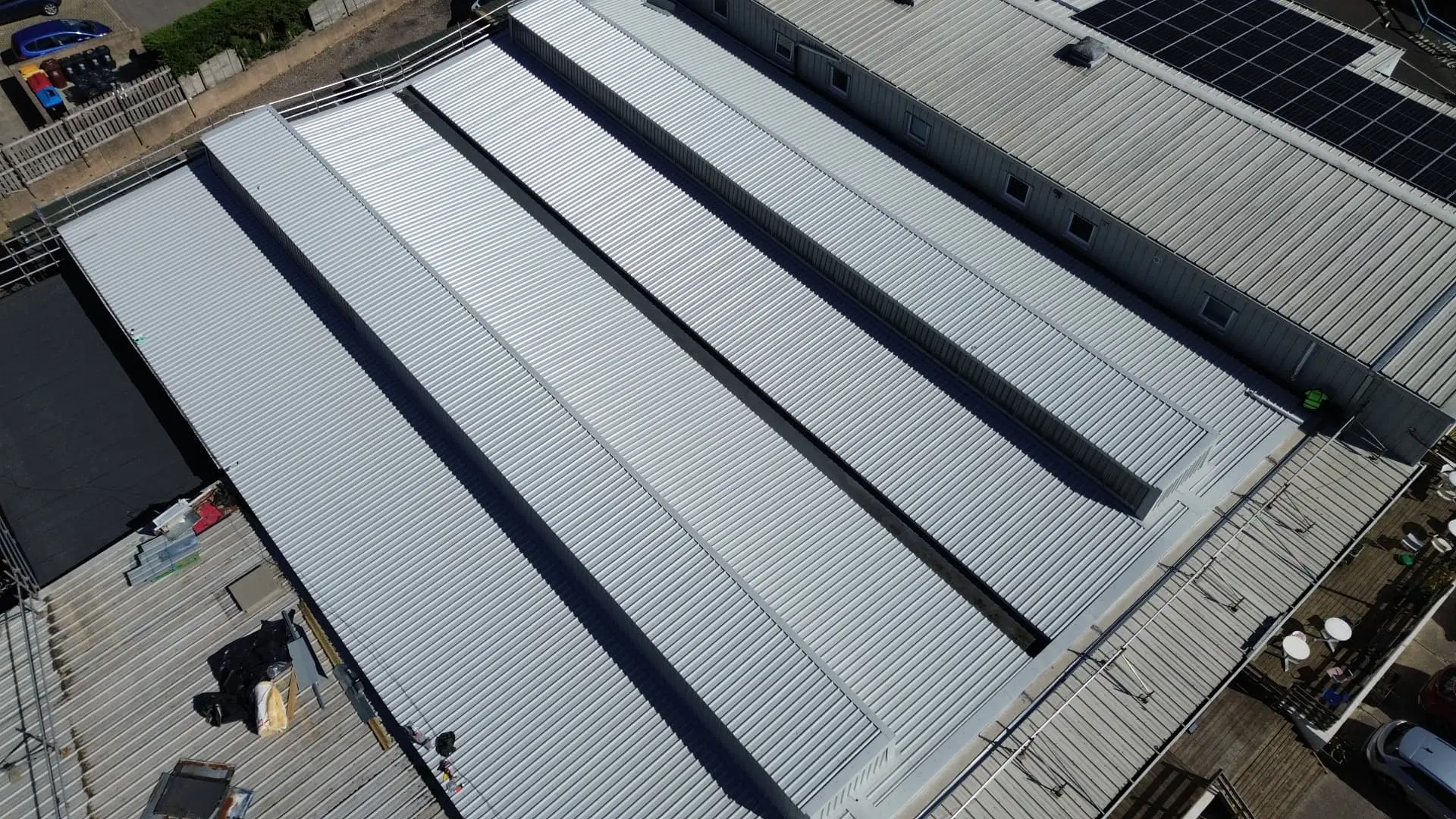 Overhead aerial view of the completed light grey metal overclad roof at Faith Church, Newport