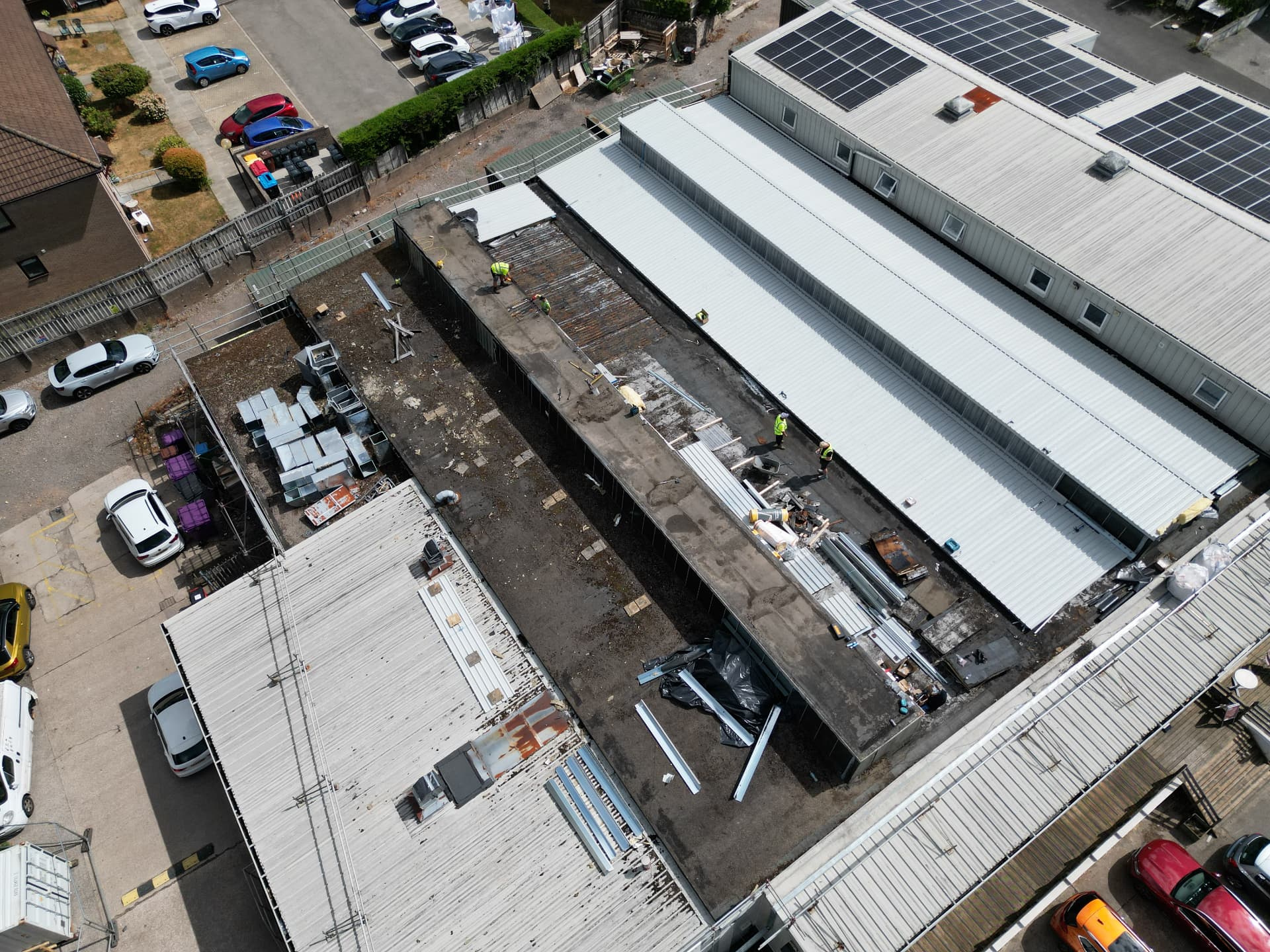 Aerial view of the existing flat roof stripped back to the deck beside the new metal roof at Faith Church
