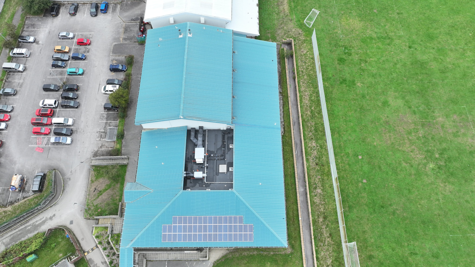 Aerial view of the original blue metal roofs and central flat roof at Pool Academy before works