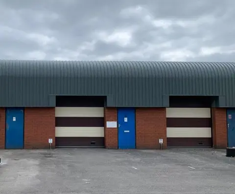 Industrial building with curved metal roof suitable for overcladding assessment